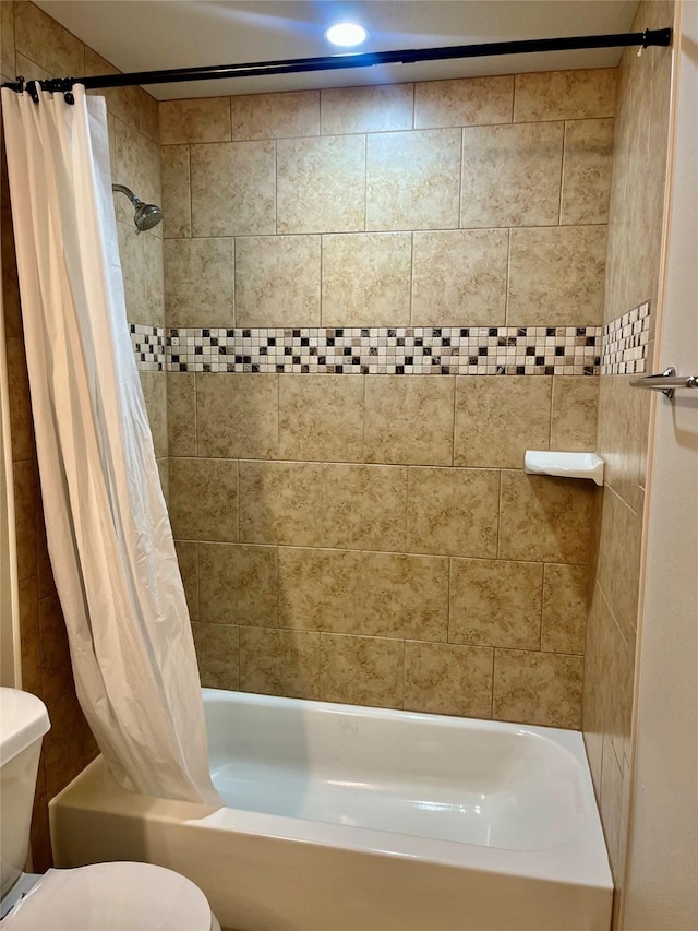 bathroom with shower / tub combo with curtain and toilet