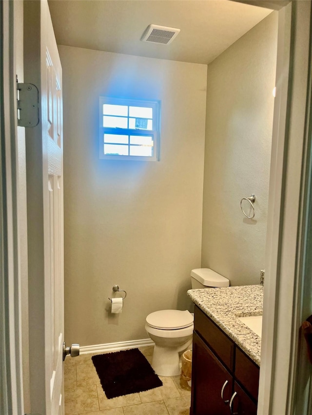 bathroom featuring vanity, tile patterned flooring, and toilet