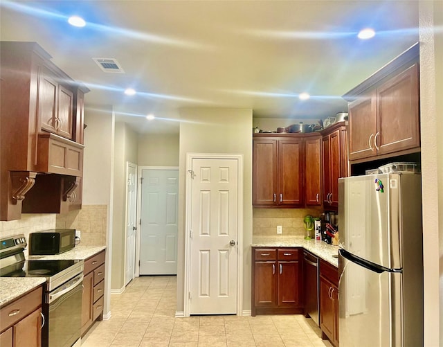 kitchen with tasteful backsplash, light tile patterned floors, and stainless steel appliances