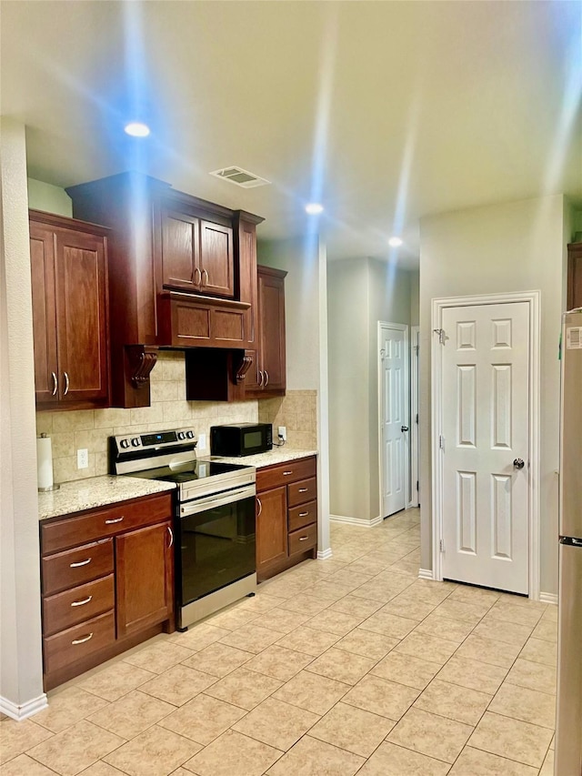 kitchen featuring stainless steel appliances, light tile patterned floors, backsplash, and light stone counters