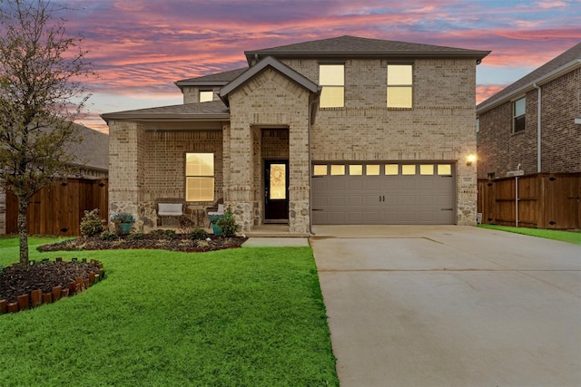 view of front of home with a front yard, concrete driveway, brick siding, and fence