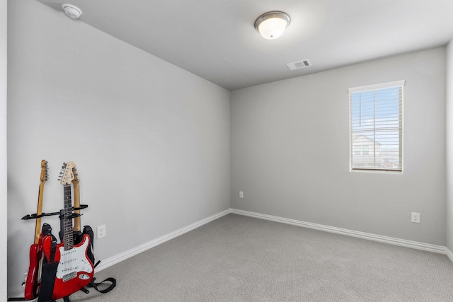 spare room with visible vents, baseboards, and carpet flooring