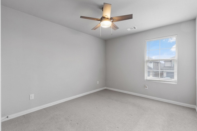 empty room featuring a ceiling fan, carpet, visible vents, and baseboards