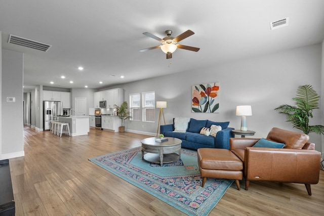 living room with ceiling fan and light wood-type flooring