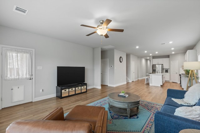 living room with ceiling fan and light wood-type flooring