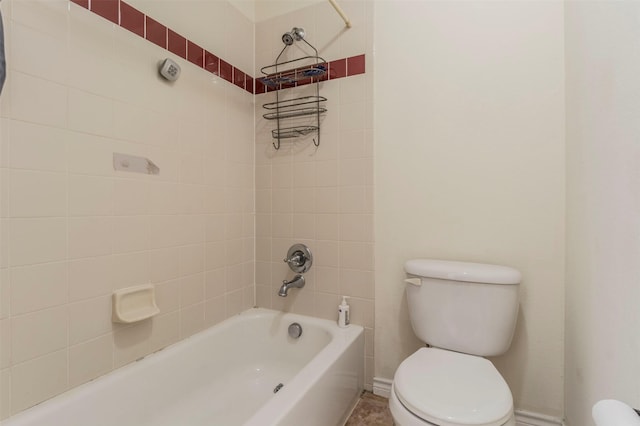 bathroom with tiled shower / bath combo and toilet