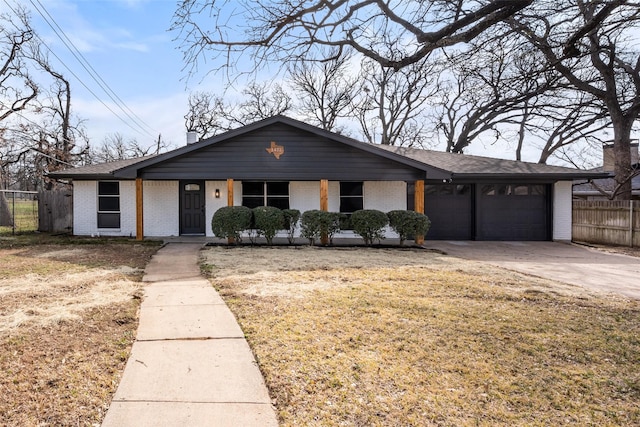 view of front of house with an attached garage, fence, brick siding, and driveway