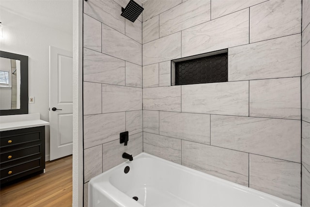 bathroom featuring vanity, tiled shower / bath combo, and wood-type flooring