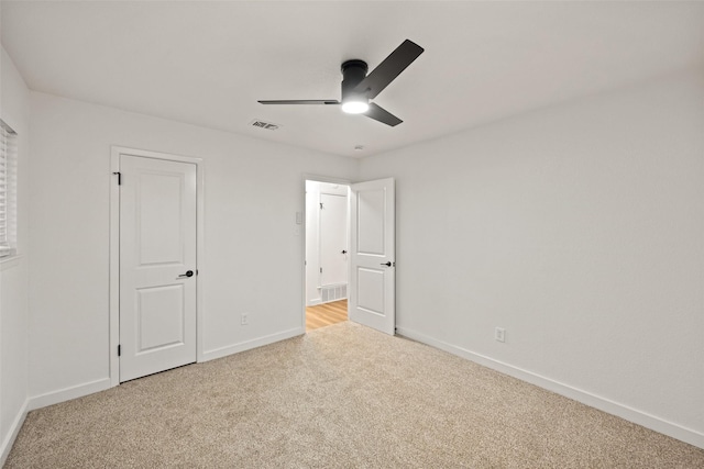 unfurnished bedroom featuring light colored carpet and ceiling fan