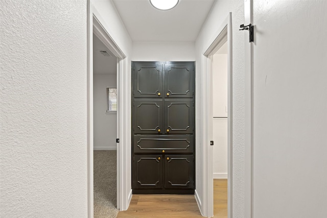 hallway with light hardwood / wood-style floors