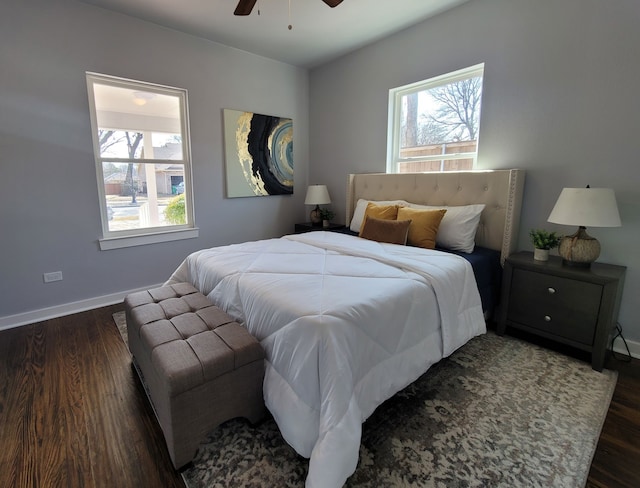 bedroom featuring multiple windows, dark hardwood / wood-style floors, and ceiling fan