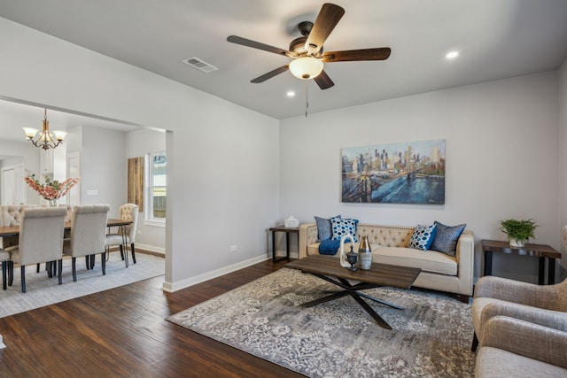 living room featuring dark wood-type flooring and ceiling fan with notable chandelier