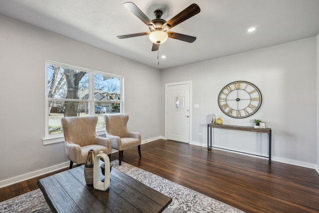 living area featuring ceiling fan and dark hardwood / wood-style flooring