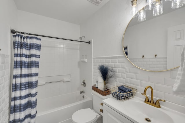 full bathroom featuring shower / bathtub combination with curtain, vanity, toilet, and tile walls