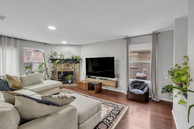 living room featuring dark wood-type flooring and a fireplace