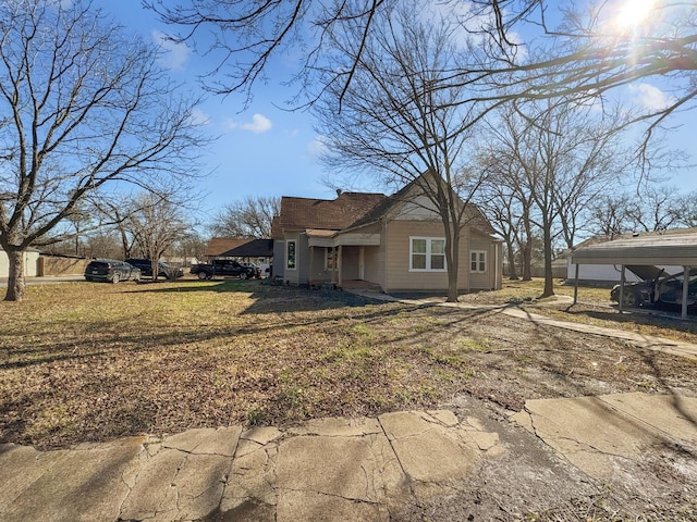 exterior space with a carport and a lawn