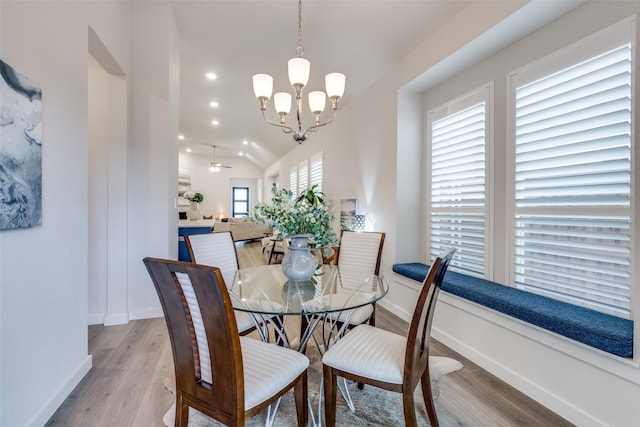 dining room with vaulted ceiling, a notable chandelier, and light wood-type flooring