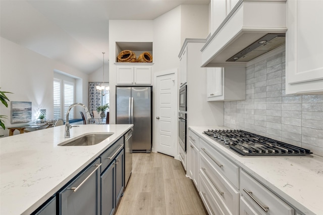 kitchen featuring premium range hood, white cabinetry, stainless steel appliances, and light stone countertops