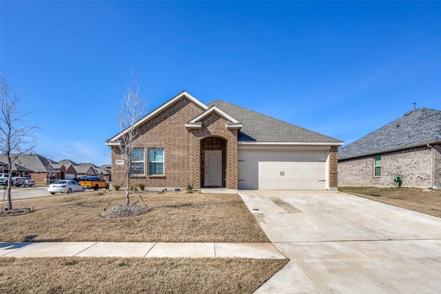 ranch-style home with a garage, brick siding, driveway, and a shingled roof