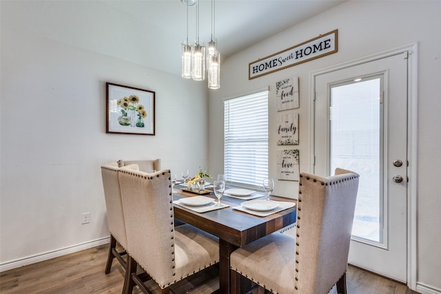 dining area with a wealth of natural light, baseboards, and wood finished floors