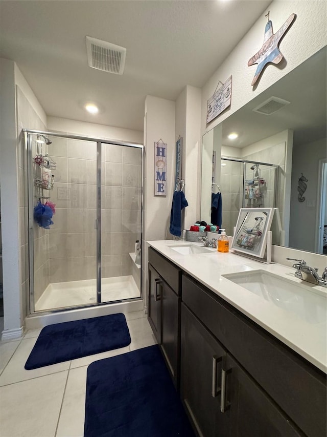 bathroom featuring vanity, a shower with shower door, and tile patterned floors