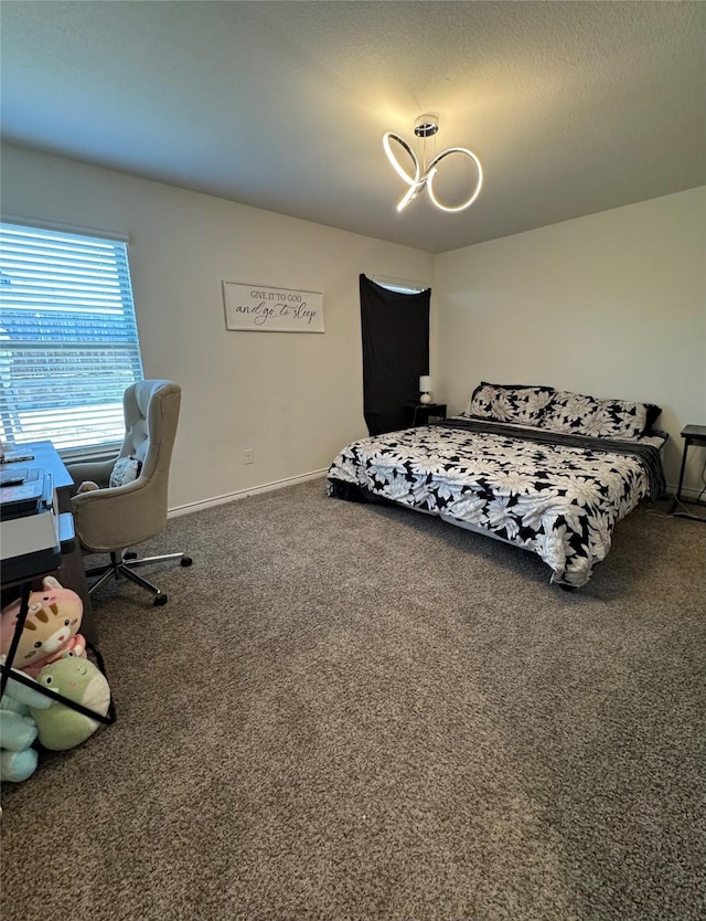 carpeted bedroom with an inviting chandelier and a textured ceiling