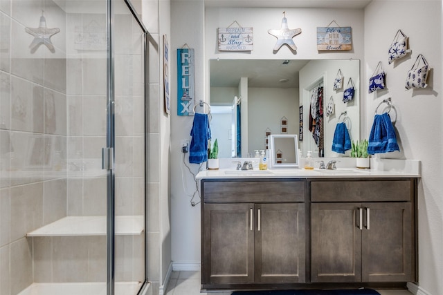 bathroom featuring double vanity, a shower stall, and a sink