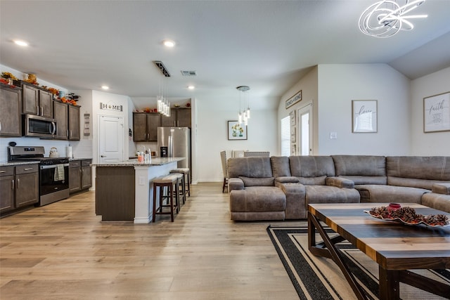 living area with a chandelier, light wood-style flooring, and recessed lighting