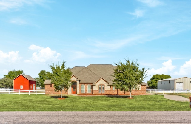 view of front of home with an outdoor structure and a front lawn