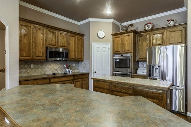 kitchen featuring backsplash, crown molding, and appliances with stainless steel finishes