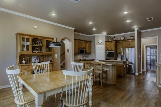 dining space featuring ornamental molding and dark hardwood / wood-style floors