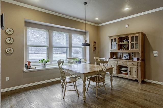 dining space with ornamental molding and dark hardwood / wood-style floors