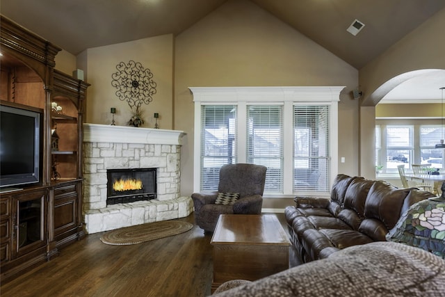 living room featuring high vaulted ceiling, dark wood-type flooring, and a fireplace