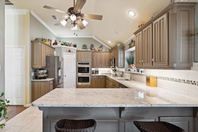 kitchen featuring a kitchen breakfast bar, kitchen peninsula, and appliances with stainless steel finishes