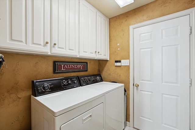 clothes washing area featuring washing machine and dryer and cabinets