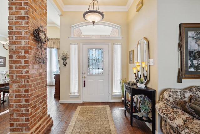 entrance foyer featuring crown molding, a towering ceiling, and dark hardwood / wood-style flooring