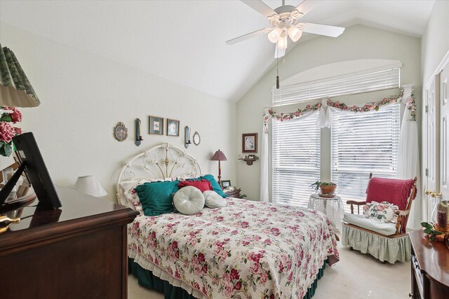 carpeted bedroom with ceiling fan and vaulted ceiling