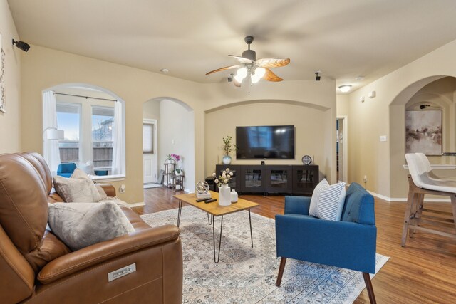 living room featuring dark wood-type flooring and ceiling fan