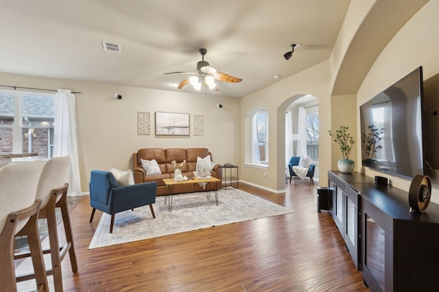 living room with baseboards, visible vents, ceiling fan, and wood finished floors