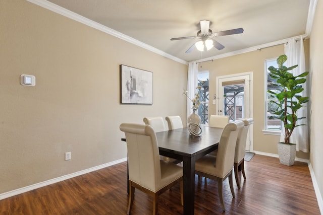 dining room with ornamental molding, dark wood finished floors, baseboards, and a ceiling fan