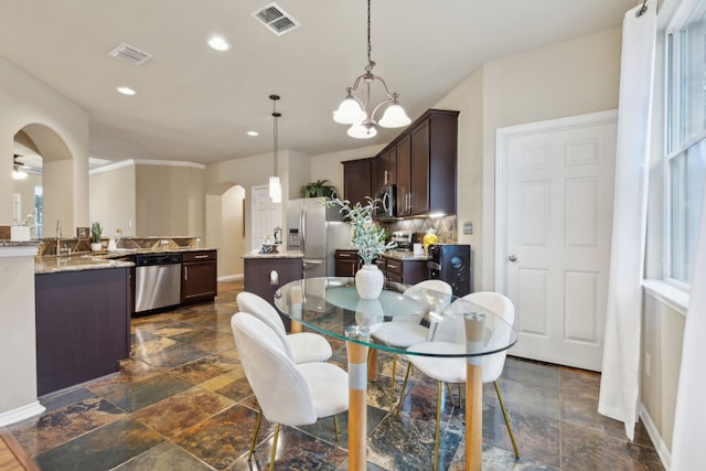 dining area featuring visible vents, arched walkways, baseboards, and recessed lighting