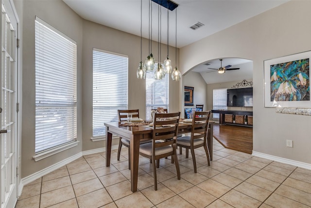 dining space with light tile patterned flooring, ceiling fan, and vaulted ceiling