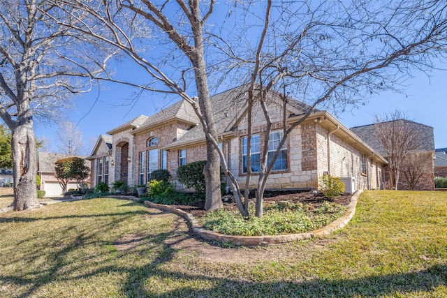 view of side of home with a yard and central AC