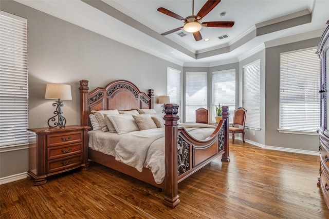 bedroom with dark hardwood / wood-style flooring, crown molding, a raised ceiling, and ceiling fan