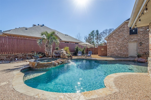 view of pool with an in ground hot tub, pool water feature, and a patio