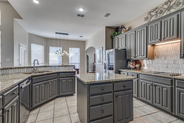 kitchen with stainless steel appliances, a center island, sink, and gray cabinets