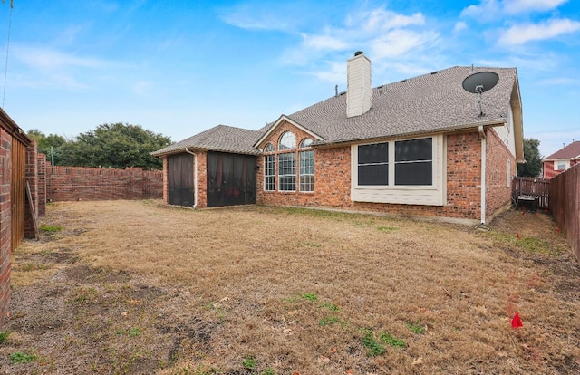 back of house featuring a yard and a sunroom