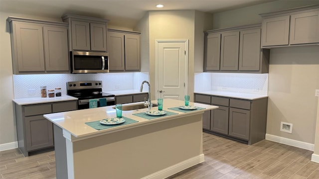 1744 River Bend Rd, Burleson, TX 76028 - kitchen with appliances with stainless steel finishes, gray cabinetry, baseboards, a sink, and light wood finished floors
