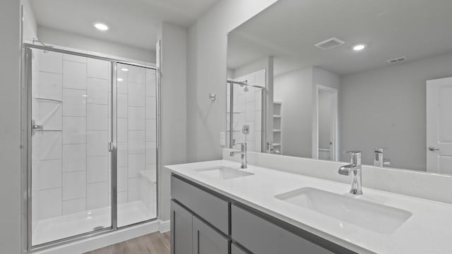 bathroom featuring an enclosed shower, vanity, and hardwood / wood-style flooring