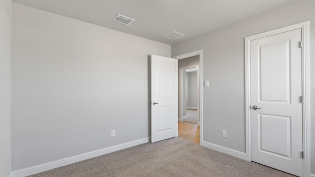 unfurnished bedroom featuring light carpet